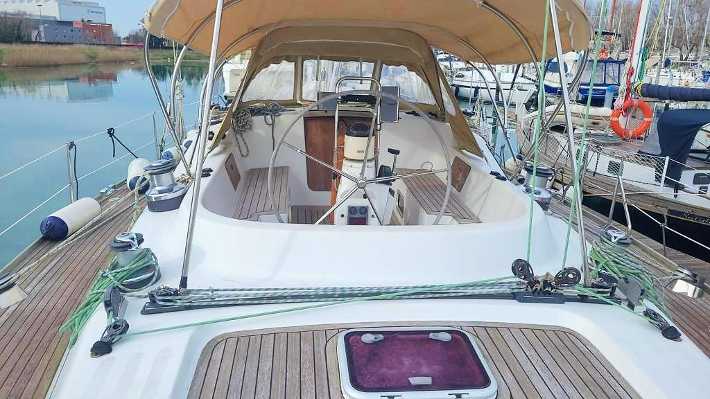 2002 Comar Comet 51 Dh yacht with wooden deck and canopy, docked at marina.