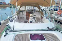 2002 Comar Comet 51 Dh yacht with wooden deck and canopy, docked at marina.