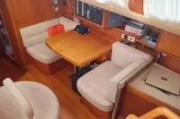 Interior of 2002 Comar Comet 51 Dh yacht with cozy seating and wooden finishes.