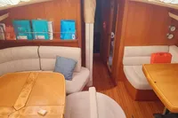 Interior of 2002 Comar Comet 51 Dh yacht with cozy seating and wooden tables.