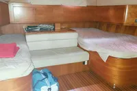 Interior of 2002 Comar Comet 51 Dh yacht with wooden finish and cozy sleeping area.
