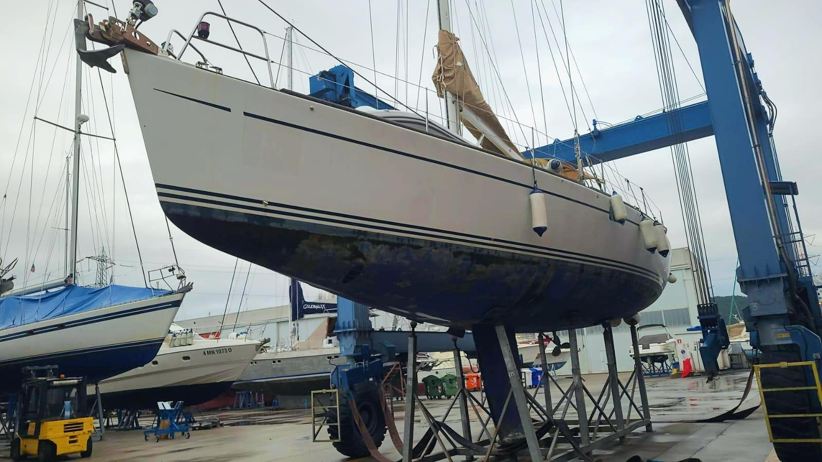 Sailboat Comar Comet 51 Dh 2002 on a lift in a shipyard.