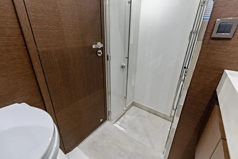  Yacht Photos Pics Modern bathroom interior on a 2019 Prestige 520 yacht, featuring a sleek shower and wooden accents.