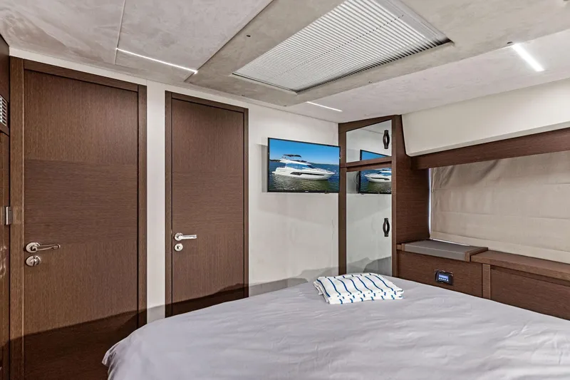  Yacht Photos Pics Luxurious bedroom interior of 2019 Prestige 520 yacht with modern design and wooden accents.