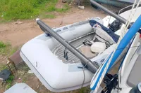 Inflatable boat on Seawind 1600 Passagemaker, 2023 model, docked on grassy terrain.