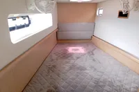 2023 Seawind 1600 Passagemaker cabin interior with bed, window, and fan.
