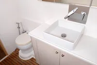 Modern bathroom in 2023 Seawind 1600 Passagemaker yacht with sink and toilet.