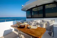 Luxurious Bering 60 yacht deck with dining table, cushions, and ocean view, 2012 model.