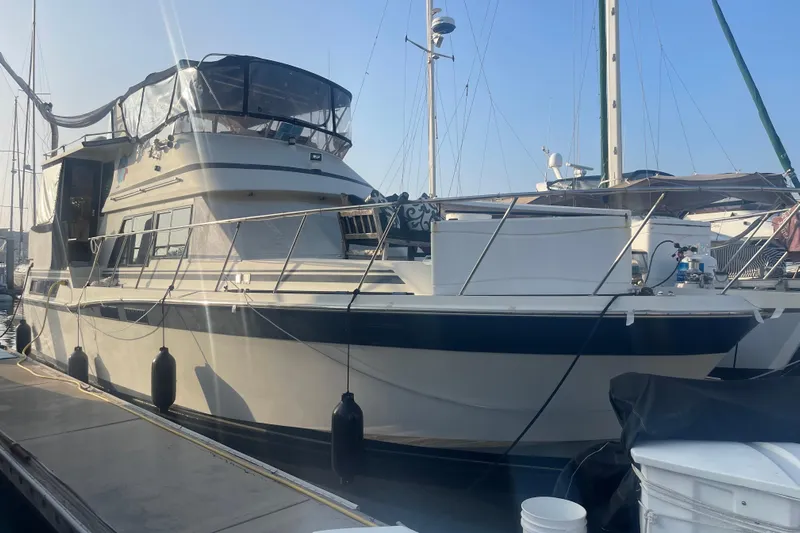  Yacht Photos Pics 1988 Marine Trader Aft Cabin yacht docked at marina under clear blue sky.