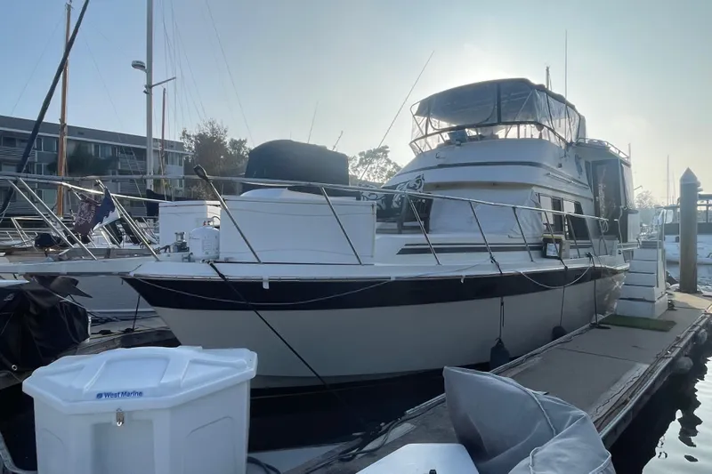  Yacht Photos Pics 1988 Marine Trader Aft Cabin yacht docked at marina, side view.