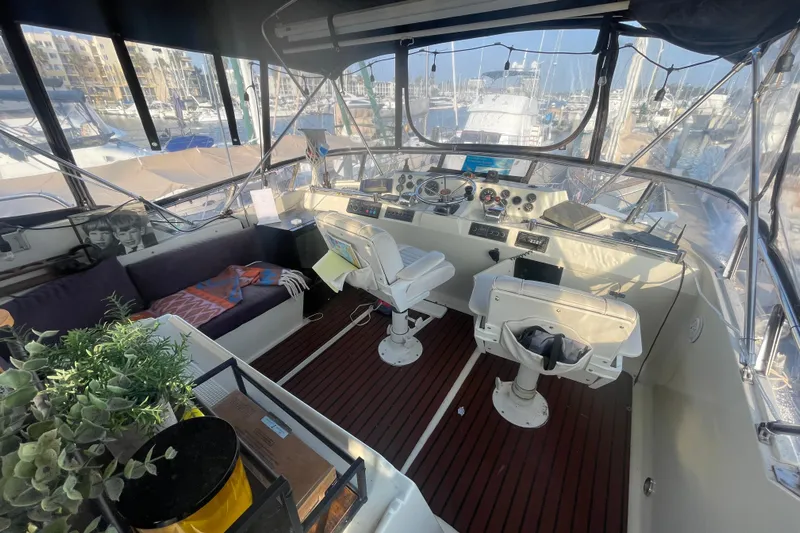  Yacht Photos Pics 1988 Marine Trader Aft Cabin helm with seating, plants, and marina view.