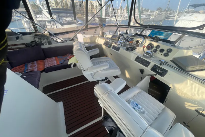  Yacht Photos Pics 1988 Marine Trader Aft Cabin helm with white seats and wooden flooring.