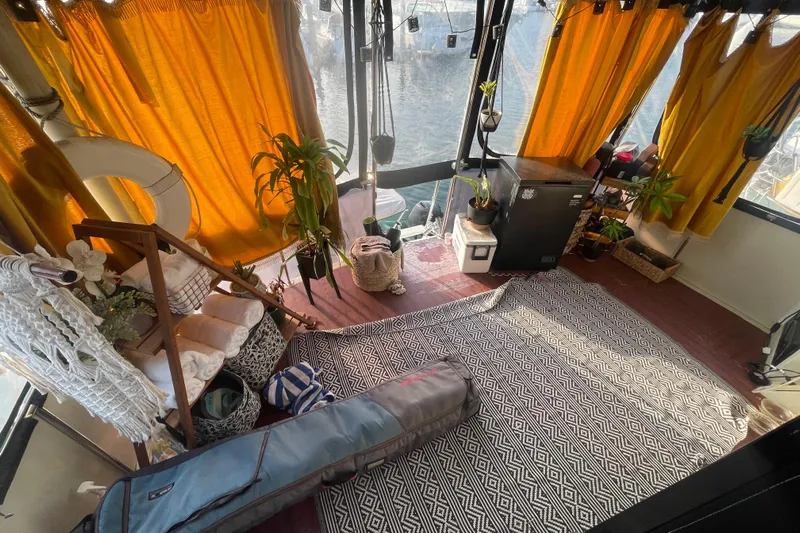  Yacht Photos Pics Cozy 1988 Marine Trader Aft Cabin interior with plants, yellow curtains, and patterned rug.