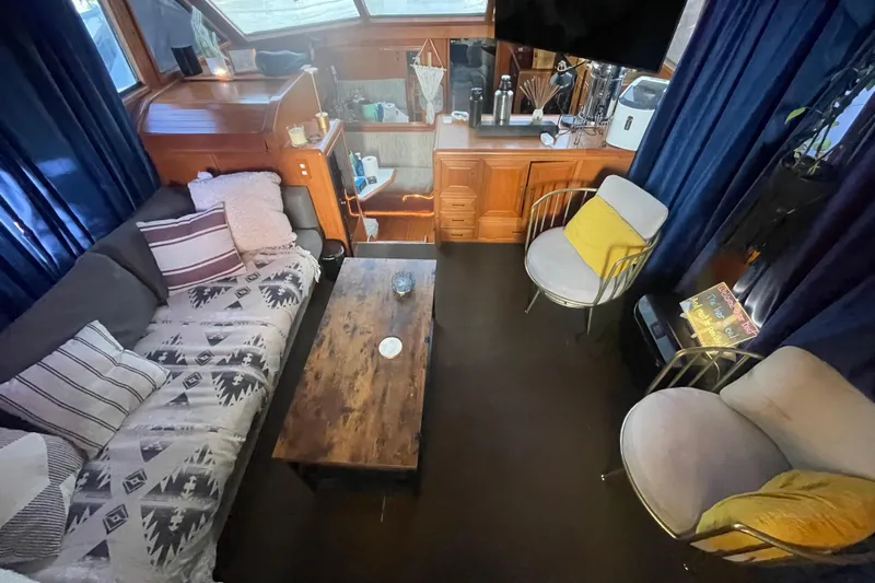  Yacht Photos Pics Cozy 1988 Marine Trader Aft Cabin interior with sofas, chairs, and wooden table.