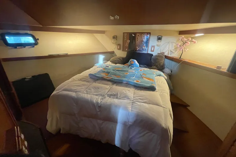  Yacht Photos Pics Cozy cabin interior of 1988 Marine Trader Aft Cabin with bed and decorative elements.