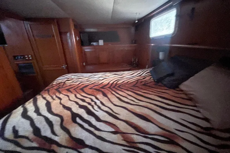  Yacht Photos Pics 1988 Marine Trader Aft Cabin interior with zebra-patterned bedding and wooden furnishings.