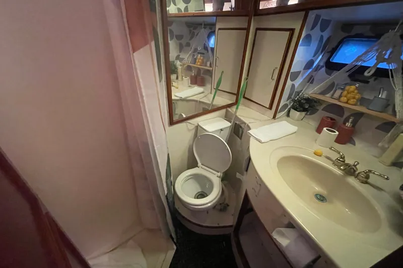  Yacht Photos Pics 1988 Marine Trader Aft Cabin bathroom with sink, toilet, and mirror.