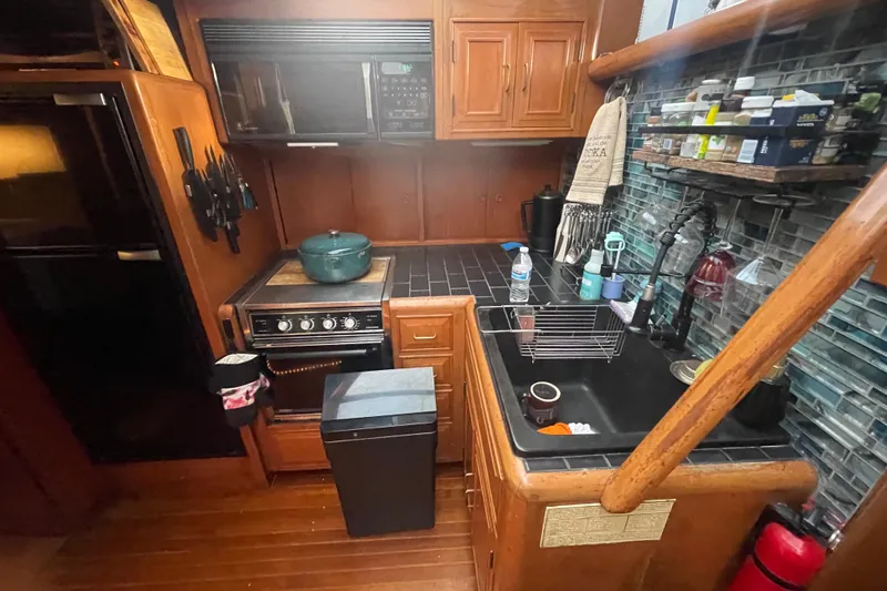  Yacht Photos Pics 1988 Marine Trader Aft Cabin kitchen with stove, sink, and wooden cabinetry.