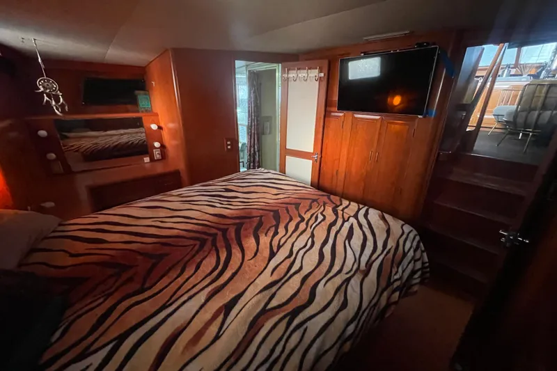  Yacht Photos Pics 1988 Marine Trader Aft Cabin bedroom with zebra-patterned bedding and wooden interior.