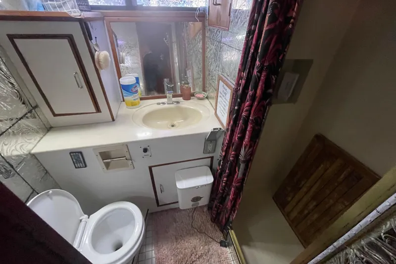  Yacht Photos Pics 1988 Marine Trader Aft Cabin bathroom with sink, toilet, and storage cabinets.