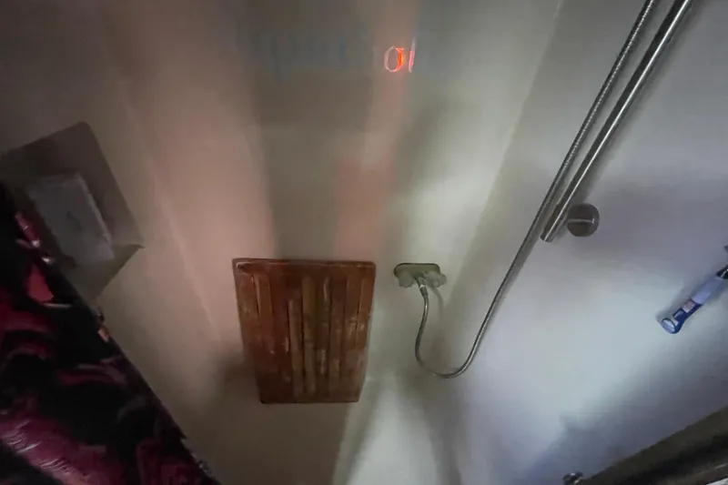  Yacht Photos Pics 1988 Marine Trader Aft Cabin shower area with wooden floor mat and showerhead.