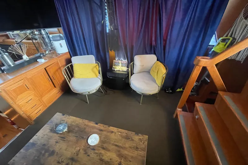  Yacht Photos Pics Cozy 1988 Marine Trader Aft Cabin interior with chairs, wooden cabinetry, and stairs.