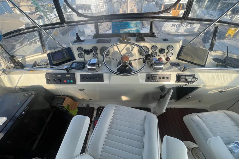  Yacht Photos Pics 1988 Marine Trader Aft Cabin helm with steering wheel, gauges, and navigation equipment.