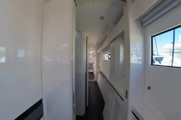 Curiosity Yacht Photos Pics 2024 HH Catamarans OC 44 interior hallway with sleek white design and windows.