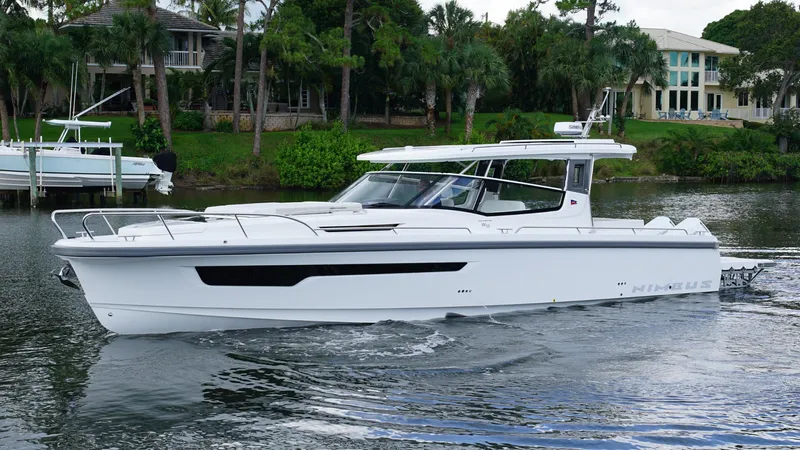 In-stock 2025 Nimbus W11 #60 Yacht Photos Pics 2025 Nimbus Weekender 11 #60 boat cruising on a calm river near lush greenery.