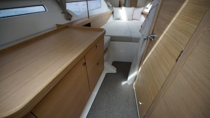In-stock 2025 Nimbus W11 #60 Yacht Photos Pics Interior of 2025 Nimbus Weekender 11 #60, featuring cozy cabin with bed and wooden cabinetry.