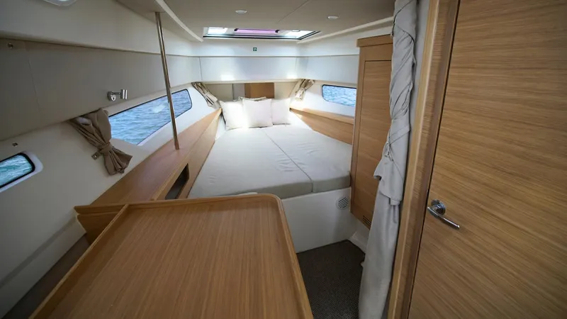 In-stock 2025 Nimbus W11 #60 Yacht Photos Pics Luxurious cabin interior of 2025 Nimbus Weekender 11, featuring a cozy bed and wooden finishes.