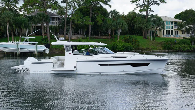 In-stock 2025 Nimbus W11 #60 Yacht Photos Pics 2025 Nimbus Weekender 11 #60 boat on a serene waterway, surrounded by lush greenery.