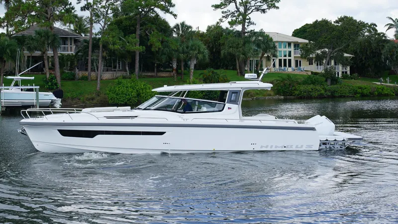 In-stock 2025 Nimbus W11 #60 Yacht Photos Pics 2025 Nimbus Weekender 11 #60 cruising on a serene lake near luxury homes.