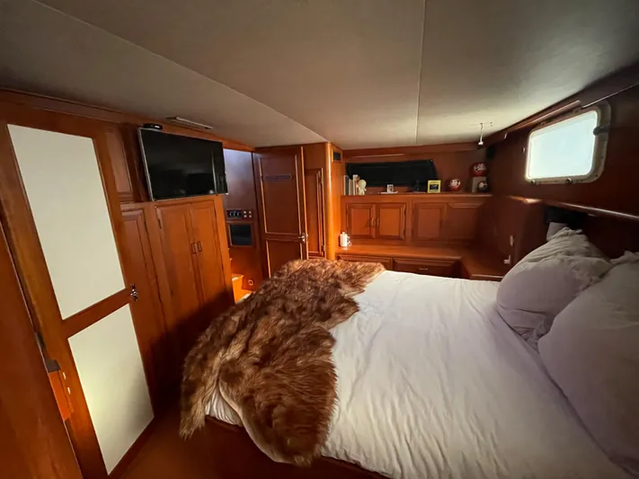  Yacht Photos Pics 1988 Marine Trader Aft Cabin interior with cozy bed, wood paneling, and window.