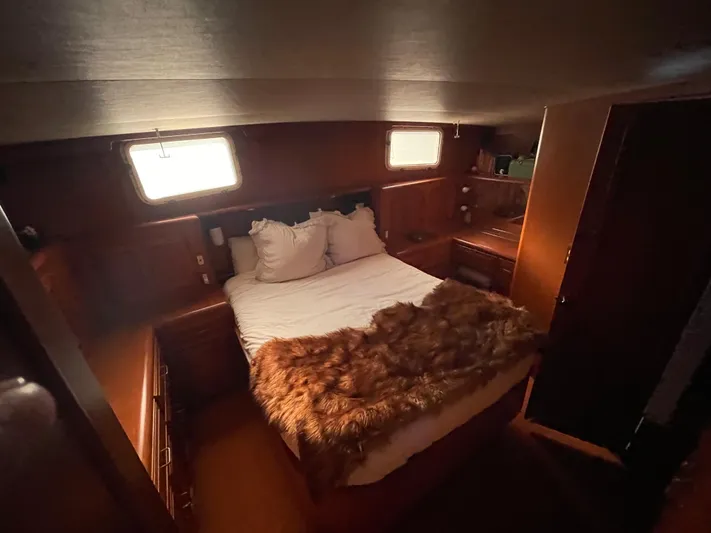  Yacht Photos Pics 1988 Marine Trader Aft Cabin interior with cozy bed, wooden furnishings, and natural light.