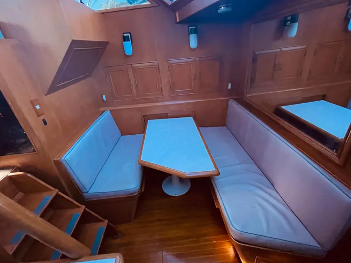  Yacht Photos Pics 1988 Marine Trader Aft Cabin interior with wooden dining area and cushioned seating.