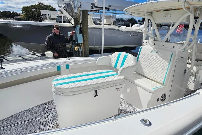  Yacht Photos Pics 2002 Yellowfin 31 Center Console boat with white and teal seating, docked by the water.