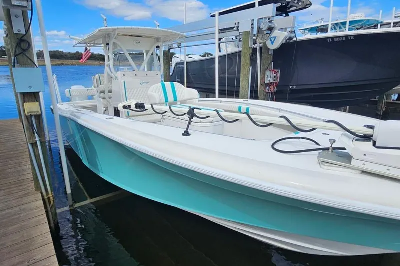  Yacht Photos Pics 2002 Yellowfin 31 Center Console boat docked, featuring a sleek turquoise and white design.