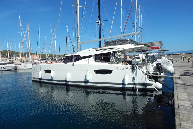  Yacht Photos Pics 2023 Fountaine Pajot Catamaran Elba 45 docked at marina under clear blue sky.