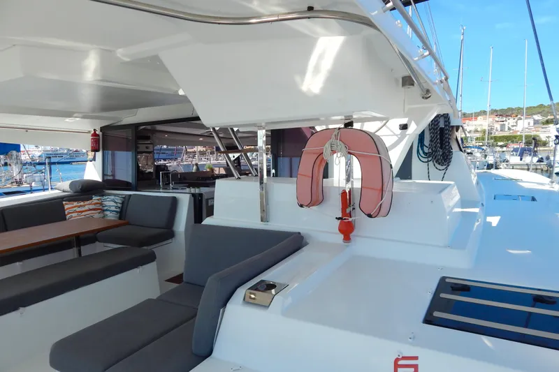  Yacht Photos Pics 2023 Fountaine Pajot Catamaran Elba 45, spacious deck with seating and life preserver.