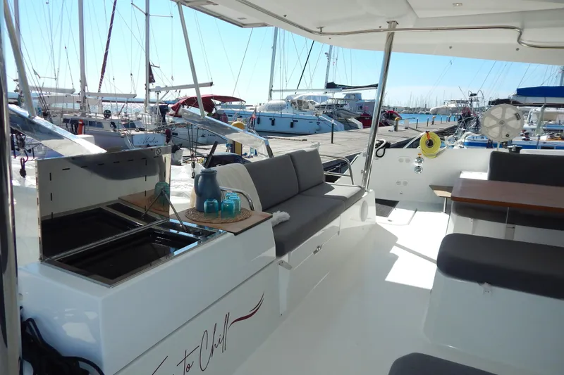  Yacht Photos Pics 2023 Fountaine Pajot Catamaran Elba 45 interior with seating and marina view.