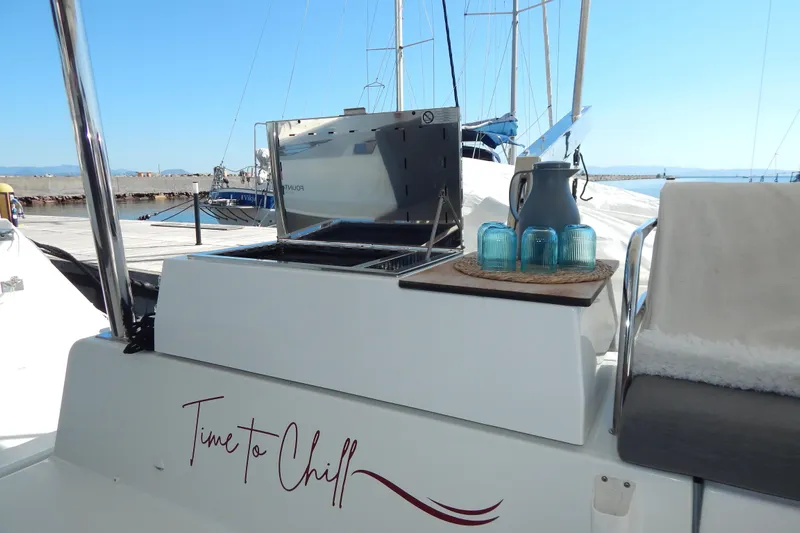  Yacht Photos Pics 2023 Fountaine Pajot Catamaran Elba 45 with outdoor seating and "Time to Chill" sign.