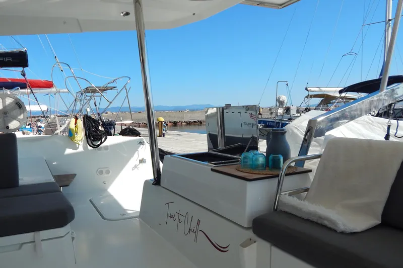  Yacht Photos Pics 2023 Fountaine Pajot Catamaran Elba 45 interior with seating and outdoor kitchen at marina.