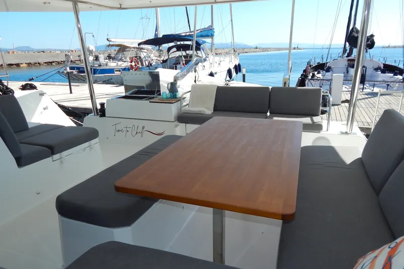  Yacht Photos Pics 2023 Fountaine Pajot Catamaran Elba 45, spacious deck with seating, docked at marina.