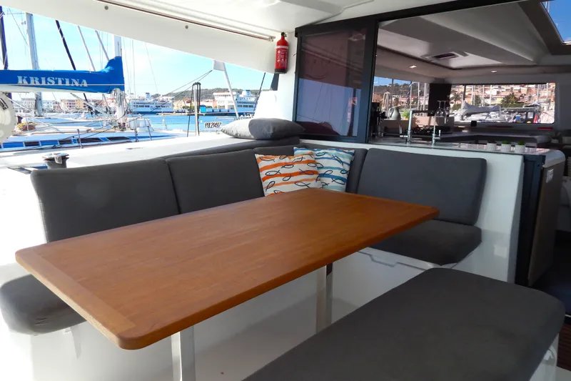  Yacht Photos Pics 2023 Fountaine Pajot Catamaran Elba 45 interior with dining area and marina view.
