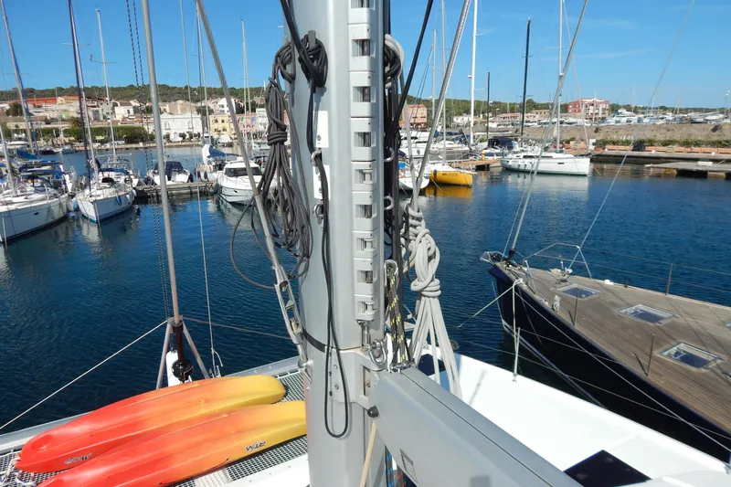  Yacht Photos Pics 2023 Fountaine Pajot Catamaran Elba 45 docked in a marina with kayaks on deck.
