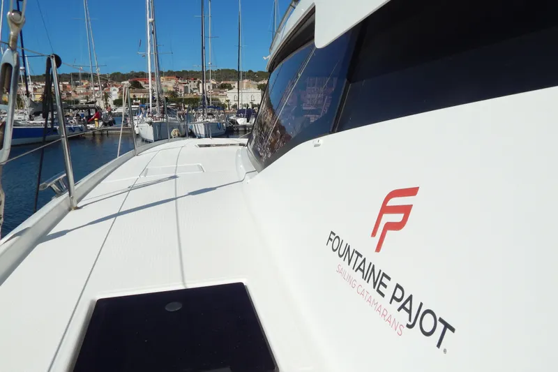  Yacht Photos Pics 2023 Fountaine Pajot Catamaran Elba 45 docked at marina, showcasing sleek design.