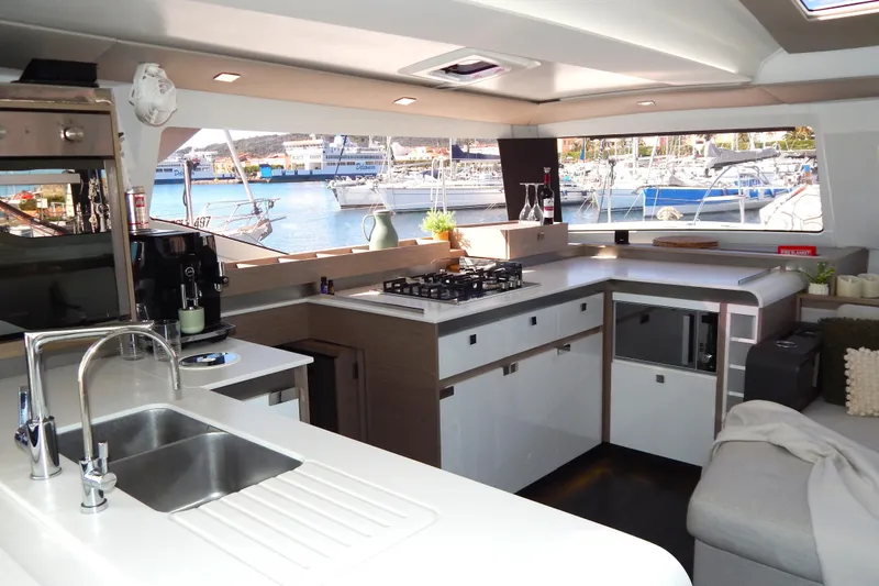  Yacht Photos Pics Modern kitchen interior of 2023 Fountaine Pajot Catamaran Elba 45 with marina view.