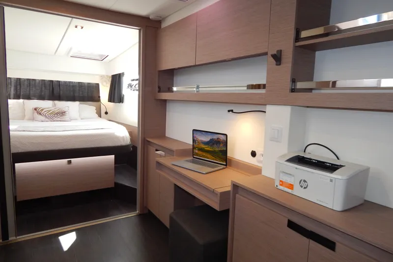  Yacht Photos Pics Modern interior of 2023 Fountaine Pajot Catamaran Elba 45 with workspace and cozy bedroom.
