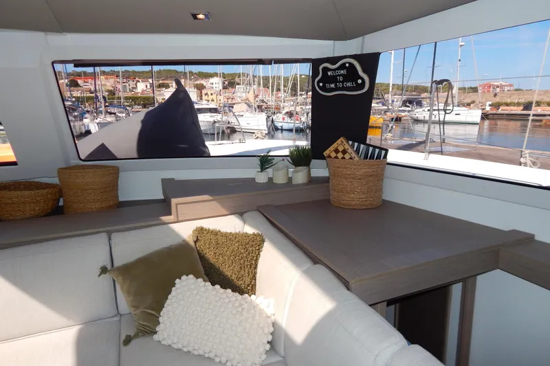  Yacht Photos Pics Interior of 2023 Fountaine Pajot Catamaran Elba 45 with cozy seating and marina view.